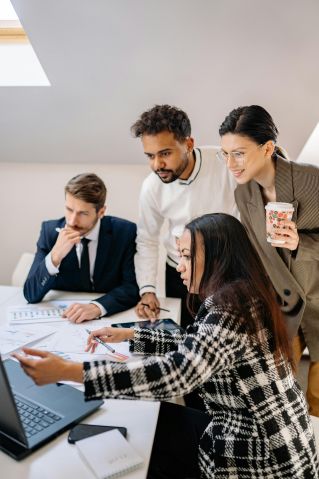 Diverse team collaborating over documents in a bright office setting, fostering teamwork.