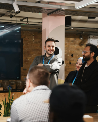 A diverse team engaging in a lively presentation in a modern office environment.